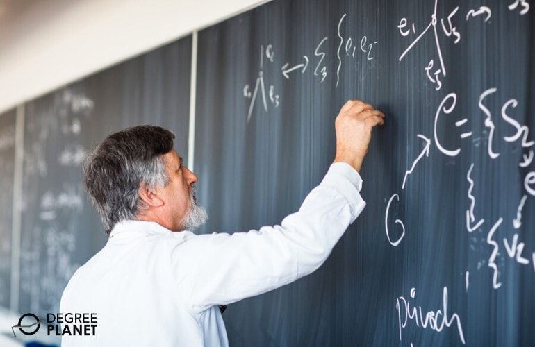 college professor writing on chalkboard